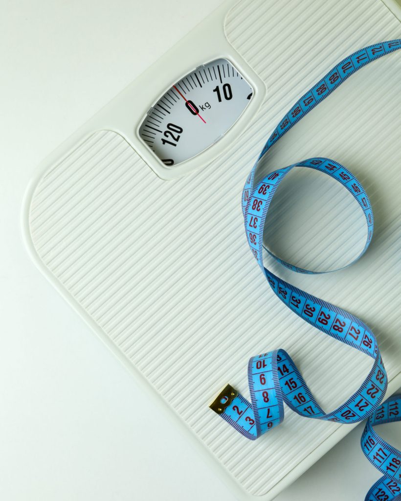Scales with measuring tape on white background