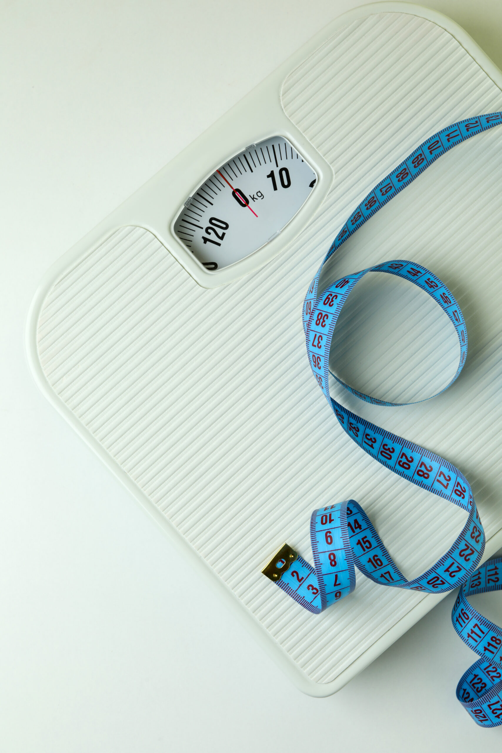 Scales with measuring tape on white background